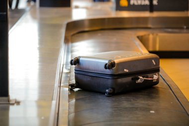 Otopeni, Romanya - 25 Şubat 2020: Uluslararası bir havaalanındaki bagaj bandında karton kutu valizi.