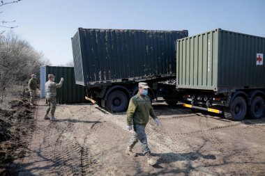 Otopeni, Romanya - 19 Şubat 2020: Romanya Ordusu personeli Covid-19 hastalarını tedavi edecek bir kampanya mobil hastanesi (ROL 2) kurulması üzerinde çalışıyor.