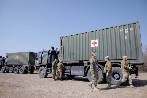Otopeni, Romania - February 19, 2020: Personnel of the Romanian Army work on the installation of a campaign mobile hospital (ROL 2) to treat Covid-19 patients.