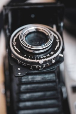 Çok eski bir körük fotoğraf makinesinin merceğindeki işaretlerle (pozlama süresi ve f-stop) alan resminin makro ve sığ derinliği (seçici odak)).