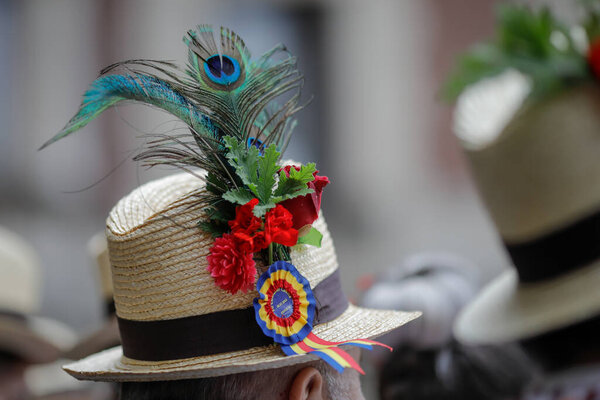Bucharest, Romania - March 5, 2020: Details with the traditional Romanian straw hat of a senior man, adorned with flowers, leaves and peacock feathers.