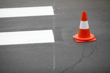 Taze boyanmış yaya geçidi ve bir trafik konisi - yol çalışması konsepti