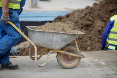 Bükreş, Romanya - 8 Mayıs 2020: İnşaat alanında el arabası süren bir inşaat işçisinin detayları.