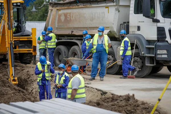 Bükreş, Romanya - 8 Mayıs 2020: Covid-19 salgını nedeniyle koruyucu maskeli inşaat işçileri.