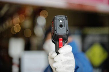 Bükreş, Romanya - 7 Mayıs 2020: Kvid-19 salgını sırasında dükkana girmeden önce müşterileri termoskanting yapan bir güvenlik görevlisiyle ayrıntılar.