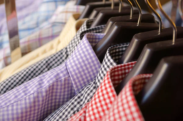 Mens plaid shirts in different colors on hangers