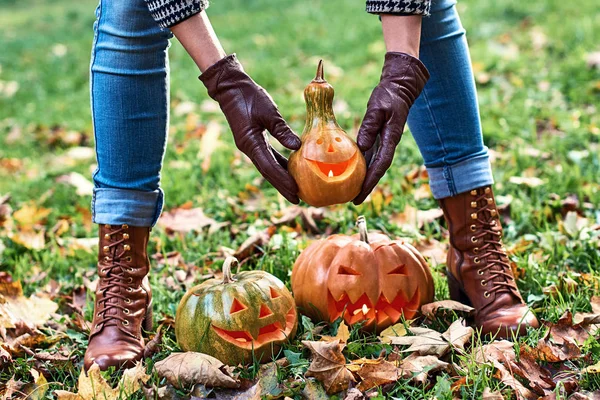 Mulher mãos em luvas de couro detém uma abóbora Halloween ao ar livre no parque de outono — Fotografia de Stock