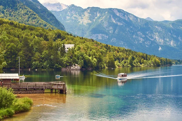 Small ship arrives to the wooden quay at lake Bohinj — Stock Photo, Image