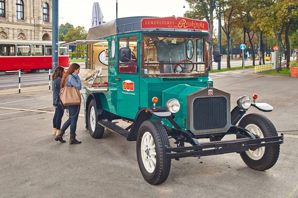 Vienne, Autriche - 22 septembre 2014 : Touristes près d'un magasin mobile de pain d'épice et de bonbons sous la forme d'une voiture d'époque dans la rue . — Photo