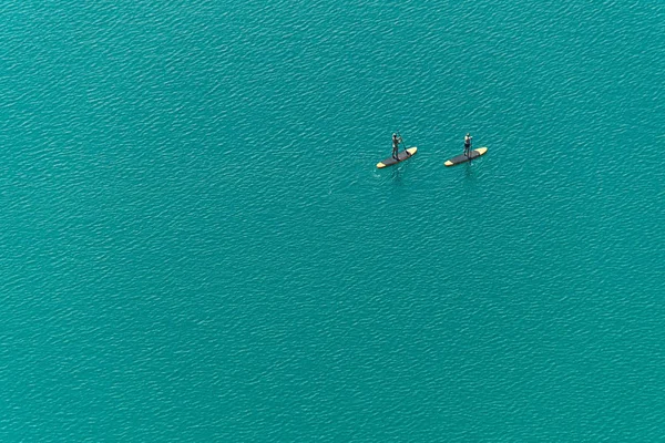 Vue aérienne de deux planchistes debout non identifiés sur le lac — Photo