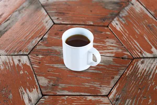 Eenvoudige witte kopje thee op de houten tafel achtergrond — Stockfoto