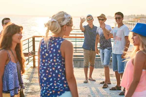 Fröhliche und unbeschwerte Gruppe von Freunden, die im Urlaub am sonnigen Sommerstrand abhängen — Stockfoto