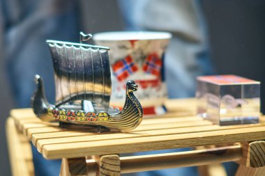 Metal Viking oyuncak gemi olarak da bilinen karve veya knarr ve Hediyelik eşya Hediyelik eşya dükkanı vitrin ulusal bayrak ile geleneksel Norveç kupa.