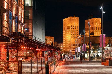 Gece şehir manzarası Oslo, Norveç, Aker Brygge Dock ile restoran ve Belediye Binası ya da Radhuset arka plan üzerinde.