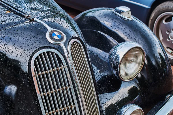 Closeup view of vintage six-cylinder sports sedan car BMW 335 released circa 1939-1941 in Germany with visible wet hood, radiator grille and logo covered with drops of rain — Stock Photo, Image