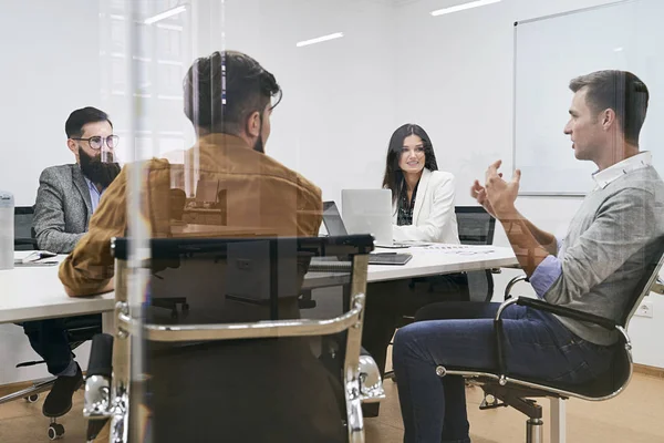 Équipe d'entreprise et responsable dans une réunion à la salle de conférence du bureau de l'entreprise informatique. Vue à travers mur de verre . — Photo