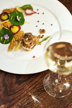 Haute cuisine ya da yüksek mutfak gıda konseptine. Kurbağa bacağı ve kemik iliği et suyu ve yenilebilir çiğ menekşe çiçekleriyle servis edilir. Nefis, özel bir yemek..