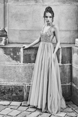 Zarif, zarif, zemin uzunluğunda, pullu, pırıltılı ve çiçek buketleri tutan yapay elmaslarla süslenmiş şifon elbisesiyle güzel nedime hanım. Düğün günü eski güzel