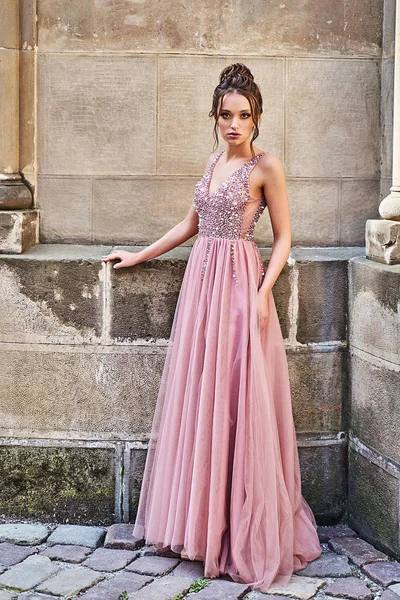 Hermosa dama de honor en magnífico elegante elegante rojo rosa piso violeta longitud v cuello vestido de gasa decorado con lentejuelas destellos y diamantes de imitación que sostienen ramos de flores. Día de la boda en — Foto de Stock