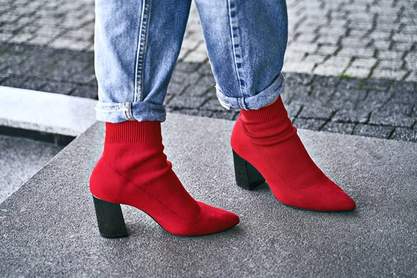 Woman legs in red sexy trendy stretch knitted fabric pointed toe block heel sock boots shoes and blue denim jeans pants — Stock Photo, Image