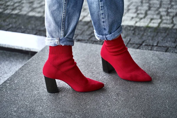 Woman legs in red sexy trendy stretch knitted fabric pointed toe block heel sock boots shoes and blue denim jeans pants — Stock Photo, Image
