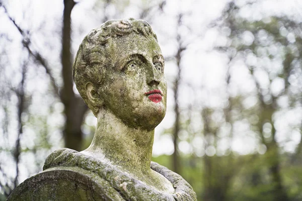 Estatua de piedra antigua en el parque público de Bruselas con labios pintados de rojo con lápiz labial o pintura —  Fotos de Stock