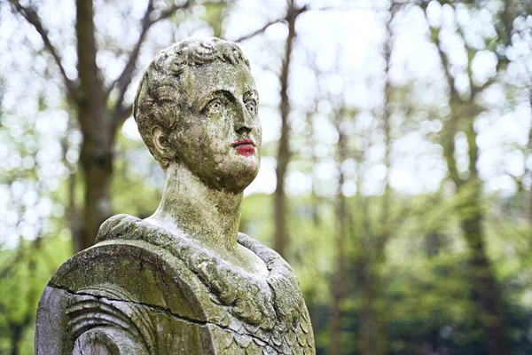 Estatua de piedra antigua en el parque público de Bruselas con labios pintados de rojo con lápiz labial o pintura —  Fotos de Stock