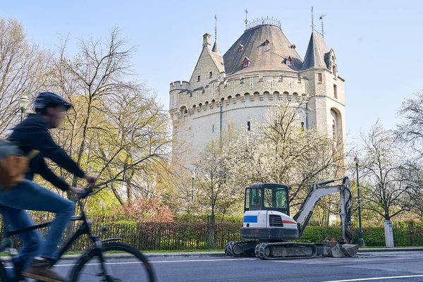 Frühling in Brüssel. Blick auf die Baggerschleier-Reparaturstraße vor dem Hallentor, mittelalterliches befestigtes Stadttor, mit Mann auf Fahrrad in Bewegung Unschärfe im Vordergrund. — Stockfoto