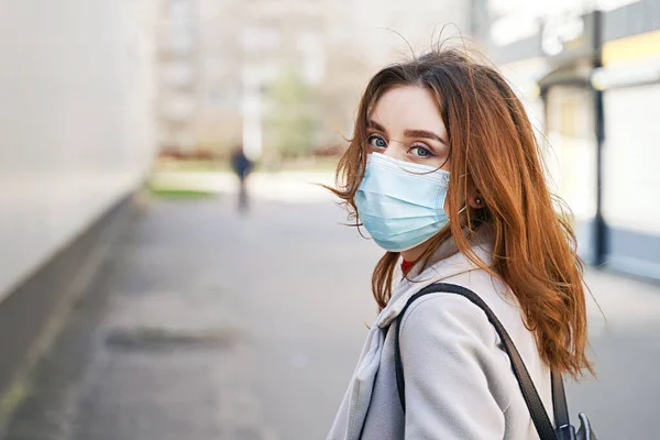 Güzel mavi gözlü, dağınık saçlı, Coronavirus MERS-Cov 'a karşı koruyucu maske takan genç bir kadın, Novel Coronavirus 2019-nCoV. Koronavirüs karantina ve pandemik konsepti.