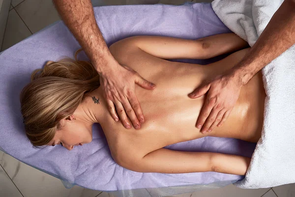 Maschio massaggiatore facendo massaggio sulla bella donna nuda corpo nel salone termale. concetto di trattamento di bellezza . — Foto Stock