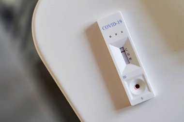 Negatif test sonucu, bir mutfak masasında COVID-19 'un yeni koronavirüsü için hızlı test cihazı kullanılması..