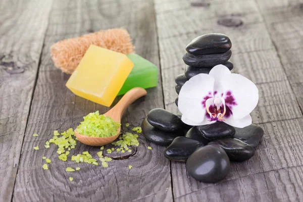 Terapia de spa com sal de banho, sabonetes, loofah e pedras pretas — Fotografia de Stock