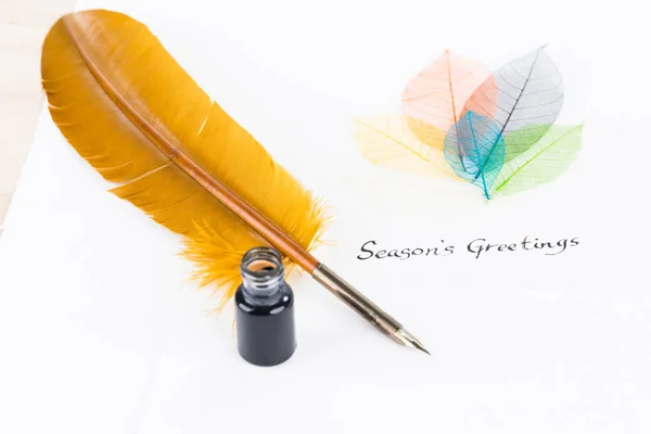 羽根ペンとコットン紙背景にスケルトンの葉の季節のご挨拶 ロイヤリティフリーのストック写真
