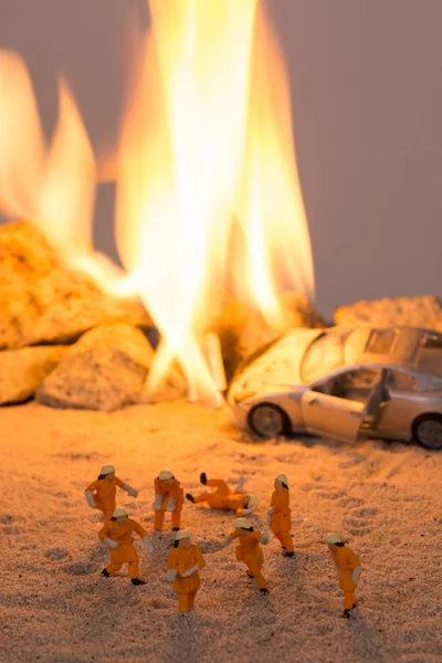 Vigili del fuoco in miniatura sulla scena di un incidente stradale in fiamme — Foto Stock