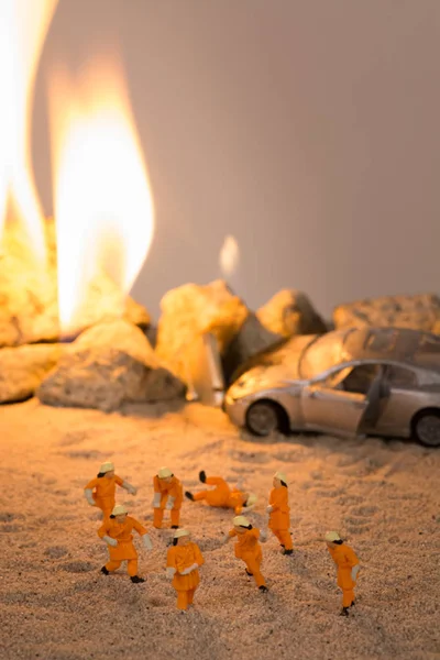 Bomberos en miniatura en una escena de accidente de coche en llamas — Foto de Stock