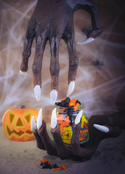 Эффект пинхола на Хэллоуин рука ведьмы, конфеты и тыквы украшения — стоковое фото