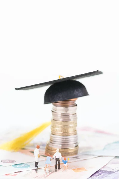 Miniature parents with two young children looking at the mortarboard — Stock Photo, Image