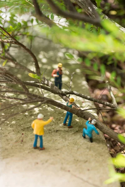 Trabajadores en miniatura despejando árboles caídos — Foto de Stock