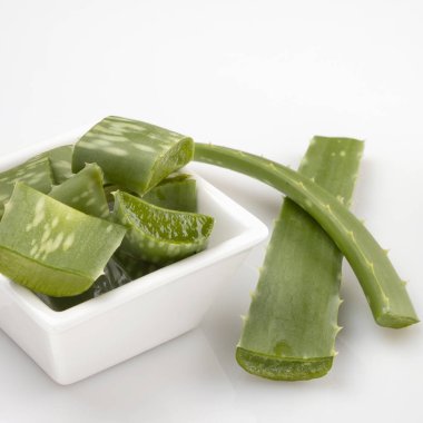 Aloe Vera beyaz arka planda beyaz kupada parçalara ayrılmış.