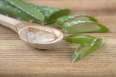 Aloe Vera yaprağı parçalara ayrılmış. Ahşap kaşıkta şeffaf aloe vera jölesi