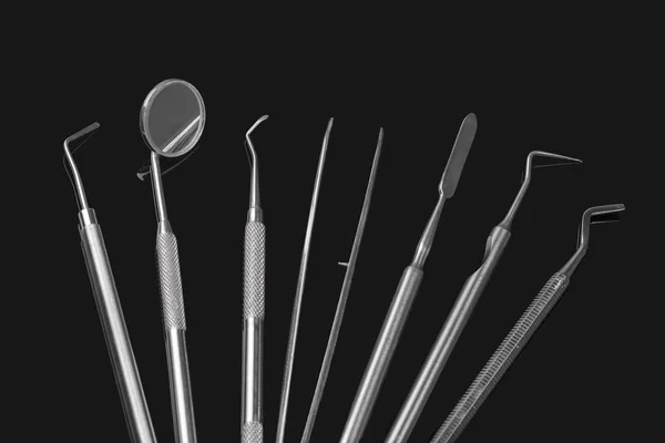 Conjunto de instrumentos dentários sobre fundo preto. Conceito minimalista no escuro — Fotografia de Stock