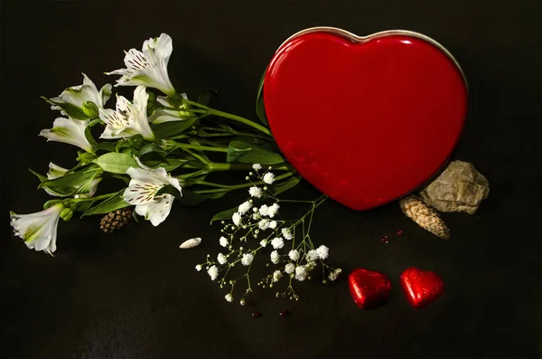 Red box in the form of heart,bouquet of white flowers and chocolates — Stock Photo, Image