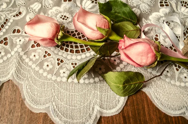 Strauß aus Knospen rosa Rosen mit Spitze Tischdecke — Stockfoto