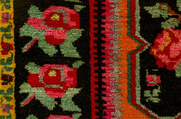 Gränsar kanten etniska mattan med röda rosor på en svart bakgrund — Stockfoto