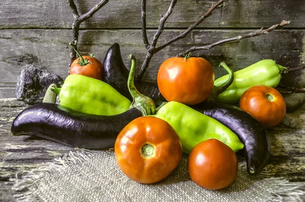 Zralá rajčata, lilek a papriky na spálené desek — Stock fotografie