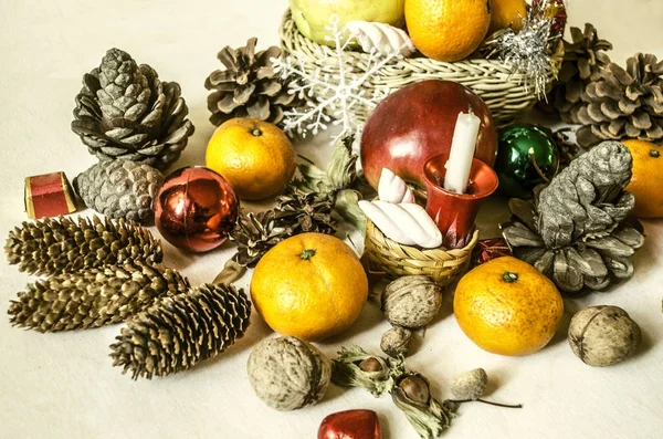 Mandarins, nozes, flocos de neve, bolas, cestas de palha com frutas — Fotografia de Stock