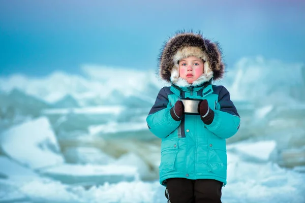 Schattig vijf jaar oude jongen hete thee drinken in de winter bevroren zee — Stockfoto