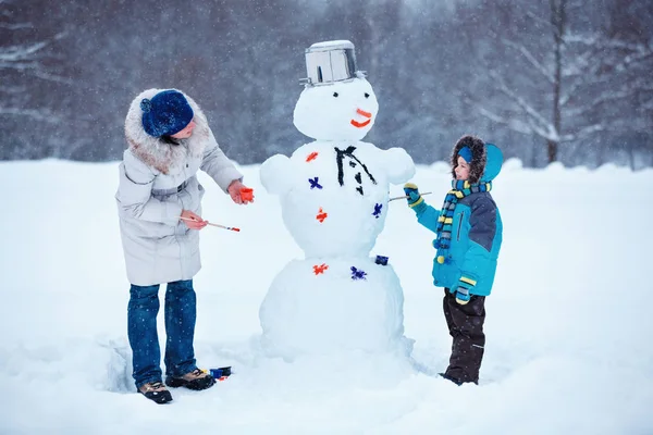 Little boy with his mother painting a snowman — Stock Photo, Image