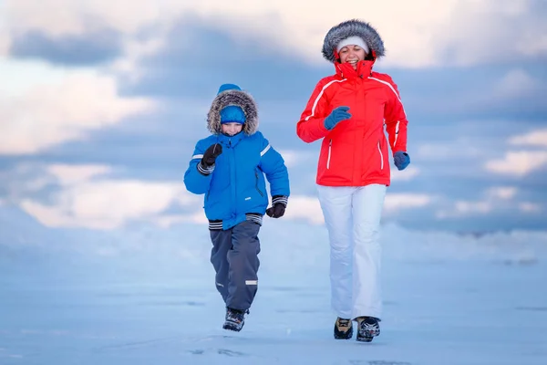 Mignon petit garçon et sa mère sur la plage glacée — Photo