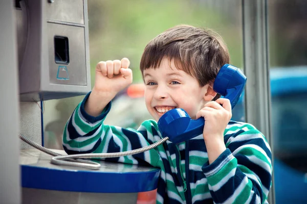 Mignon petit garçon parler sur l 'public téléphone — Photo